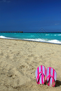 佛罗里达州尼亚海滩的沙滩上卡着条纹粉色凉鞋图片