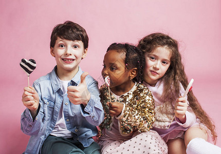白人男孩和非洲小女孩拿着糖果开图片