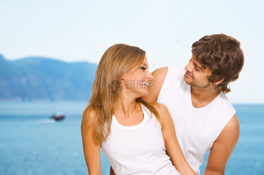 穿着休闲服的美丽年轻夫妇在海边休息图片