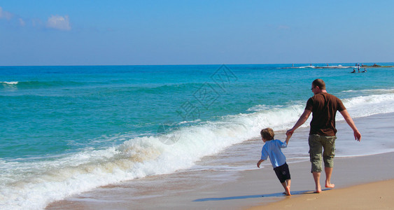 在沙滩上玩耍的父子图片