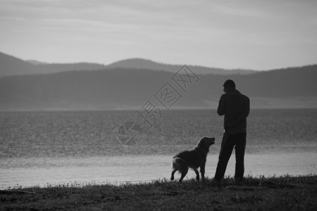日落时分高山湖附近的人和狗黑白景观图片