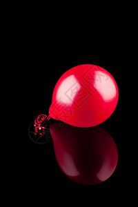 黑色背景上有反射的红色气球图片