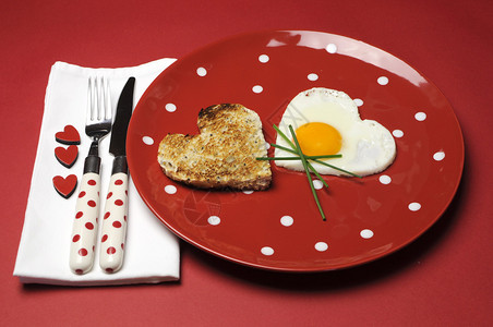 红主题情人节早餐有心形鸡蛋和烤面包图片