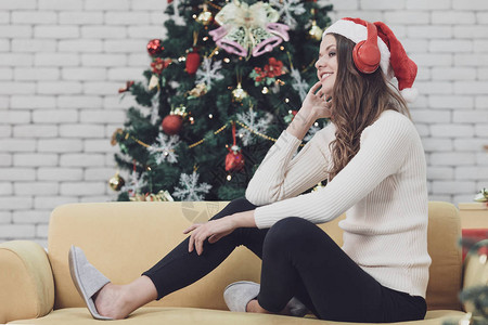 在休圣诞树前用耳机听音乐图片