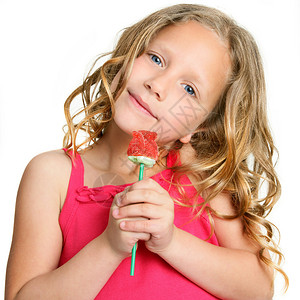 紧贴近可爱小女孩的肖像拿着红色糖果玫瑰孤立图片