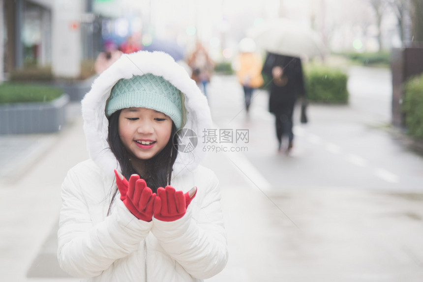 下雪天在小镇的街道上享受的女孩图片