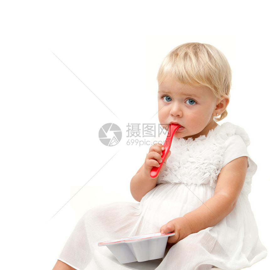 蓝眼睛女婴坐在红色勺子和无聊的脸容表情上图片