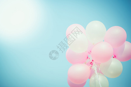 蓝色天空上粉色和白色的气球复制空间图片