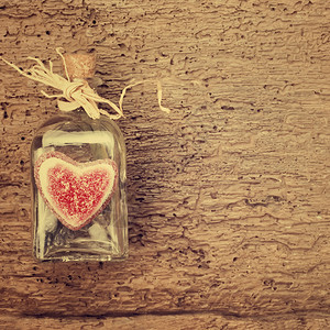 情人节卡片瓶子和软心放在古老木背景上图片