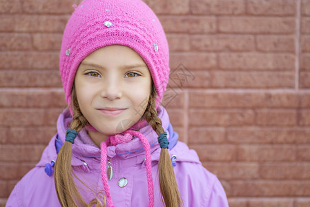 穿着粉红色大衣的美丽笑容小女孩图片