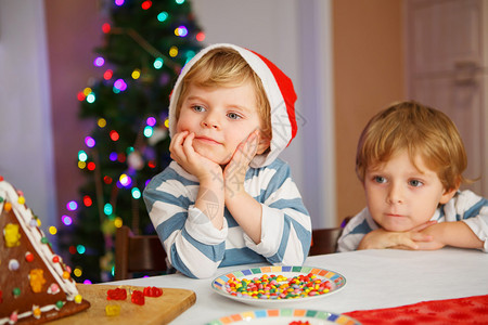 两个小兄弟姐妹男孩在圣诞节的时候快乐地看到自己制的姜饼干屋有选择地图片