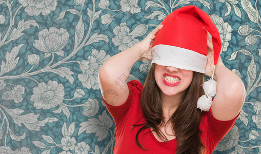 带着圣诞帽子的愤怒女人将她的眼睛遮图片