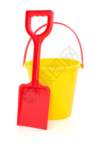 白色背景下红色的玩具铲和黄色的沙滩桶图片