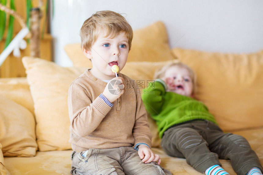 两个小兄弟男孩在电视上看电视在室内吃糖果有选择地关注儿童的前途孩子们在家图片