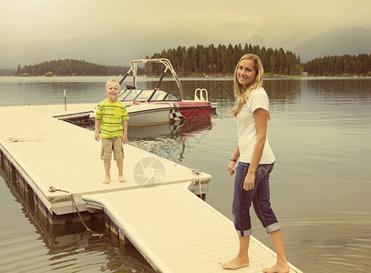 母亲和儿子在光滑的湖图片