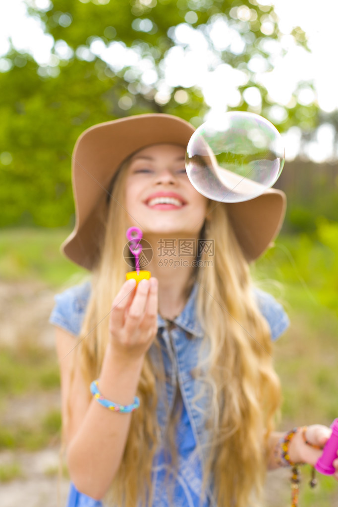 嬉皮女孩在户外吹泡图片