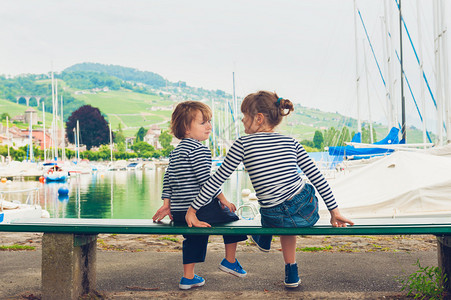 两个孩子小女孩和男孩在湖边休息穿图片