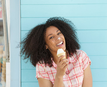 一位美丽的年轻女士在夏天在外面吃冰淇淋图片