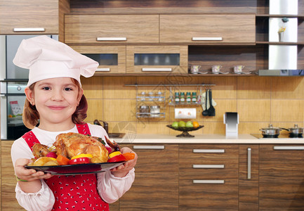 小女孩在厨房里用鸡做饭图片