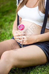 年轻孕妇在大腹部抱棒图片