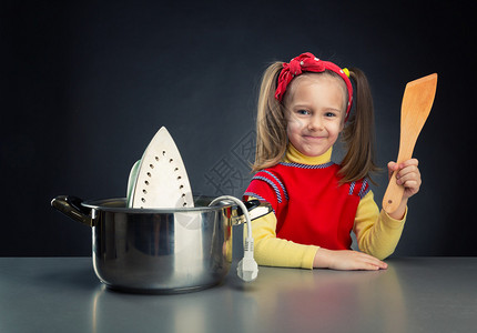 可爱的小女孩在锅里煮铁图片