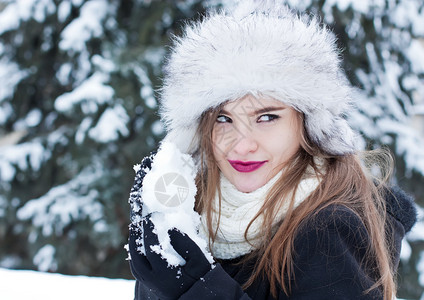 女孩正在为打雪仗准备雪球图片