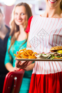 朋友或夫妇在美式快餐店吃快餐女服务员图片