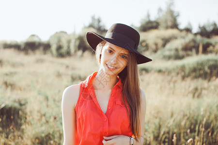穿着红色衬衫黑色帽子时髦衣服装和帽子度假风格鲜艳色彩的年轻女孩图片