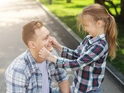 快乐的父亲和女儿在公园里微笑的男人与小图片