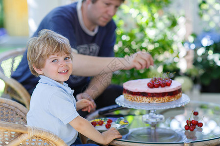小男孩和他的父亲吃樱桃蛋糕图片