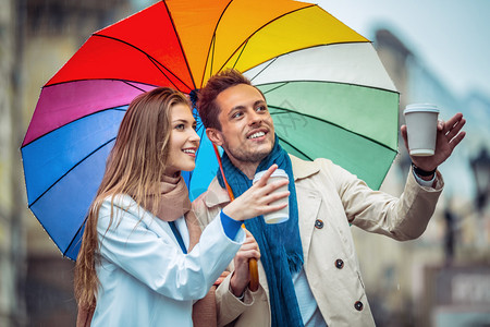 街上撑着雨伞的年轻夫妇图片
