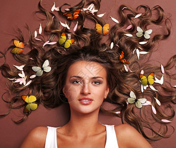 美丽的女人头发上有花瓣和蝴蝶图片