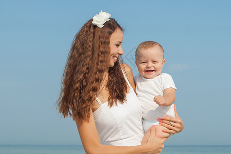 快乐的家庭年轻快乐美丽的母亲和她的儿子在海滩上玩得开心积极的人图片