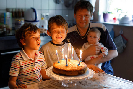可爱的快乐小男孩庆祝他的生日孩子在蛋糕上吹蜡烛父亲兄弟和小图片