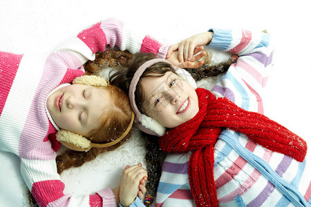 两个女孩躺在雪地里的肖像图片