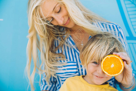 女人用橙子遮着小孩可图片