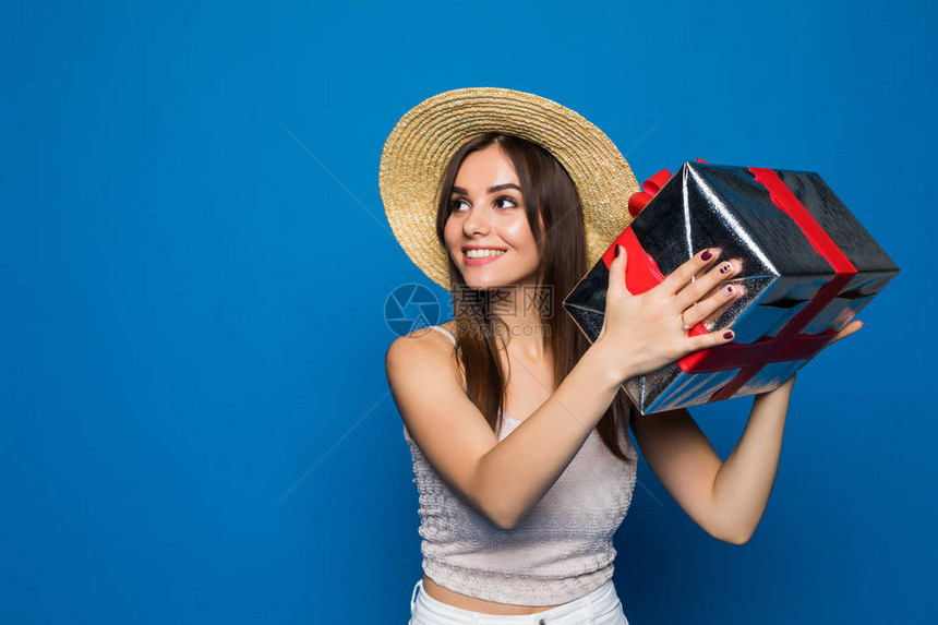一个微笑的漂亮女孩的肖像拿着礼物盒图片