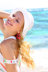 在海滩戴帽子的漂亮女孩图片