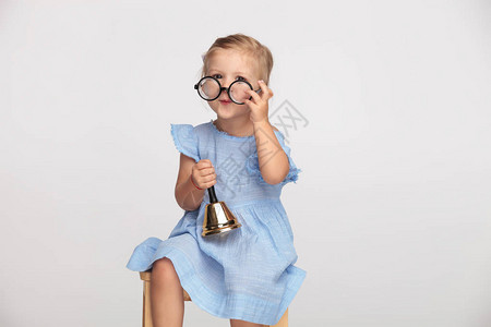 可爱的书呆女孩戴上眼镜摇铃叫着要开始背景图片
