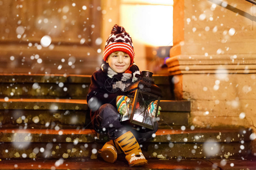 可爱的小男孩在教堂附近的楼梯上带着一盏灯笼德国圣诞市场上快乐的孩子孩子在寒冷的图片