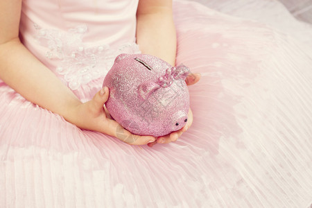 儿童手中的粉红小猪银行T图片