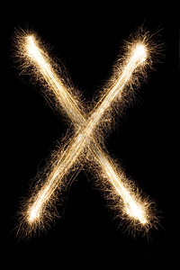 艺术字字母英文大字母X由黑色背景上的燃烧火花制成闪亮的节日派对烟花字体背景