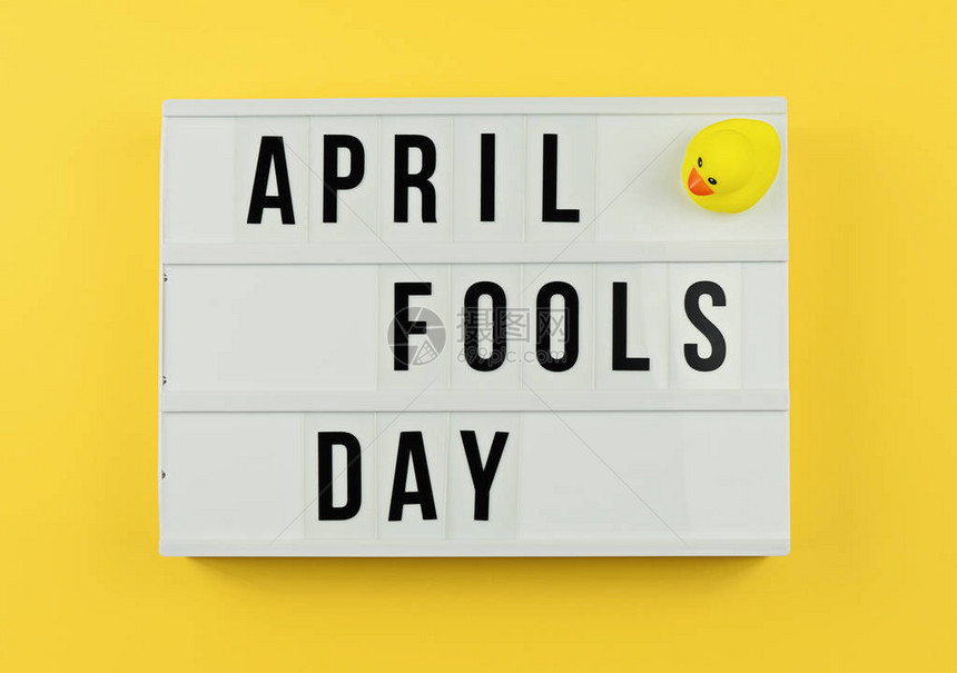 四月愚人节在电影光箱中和黄色背景的小鸭子贺卡概念上写图片