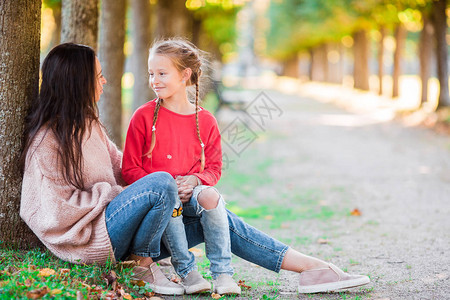 年轻妈和可爱的小女孩在阳光明媚的图片