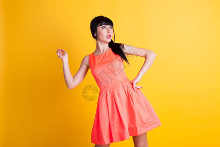 穿着橙色衣服的女孩在黄色背景图片