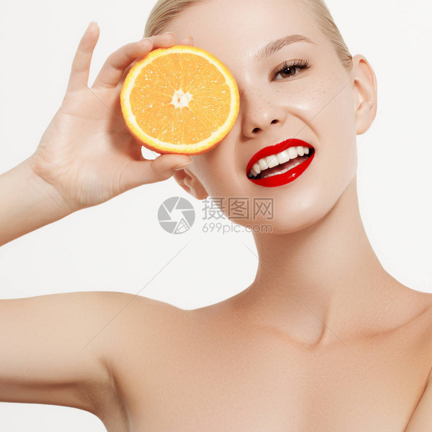 微笑的女孩用新鲜水果美女模特需要多汁的橙子有雀斑的快乐的女孩健康饮食的概念专图片