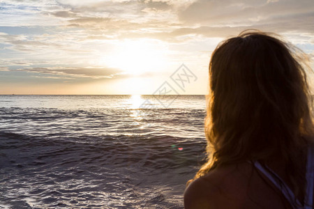 女人头发后背的概念看着太阳落下横跨图片