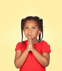 悲哀的小女孩祈祷某件东西被孤立在黄图片