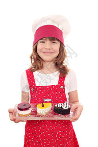 快乐的小女孩用甜蛋糕做饭图片