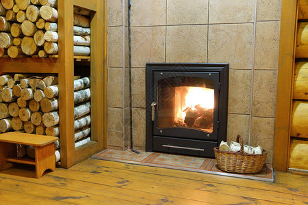 一个烧木头的炉子和一篮桦木柴火在农村的木屋里背景图片